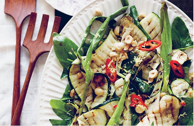 Grilled courgettes with hazelnutsartfully arranged on a platter in a recipe by Sarah Britton