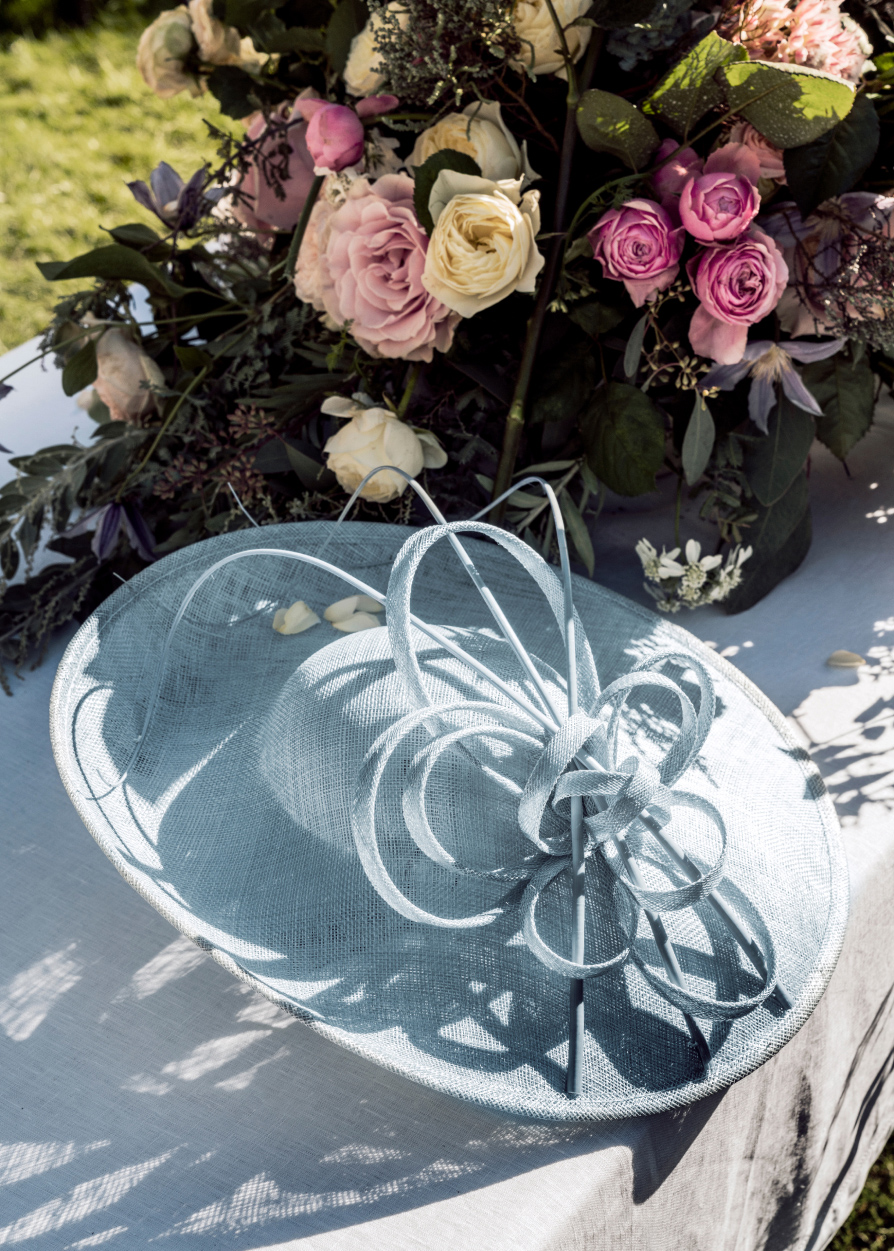 Image of blue fascinator on a table set for a wedding.