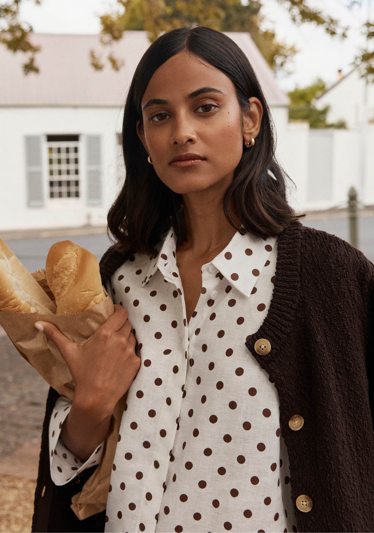 A woman wearing a Hobbs linen top and shorts.