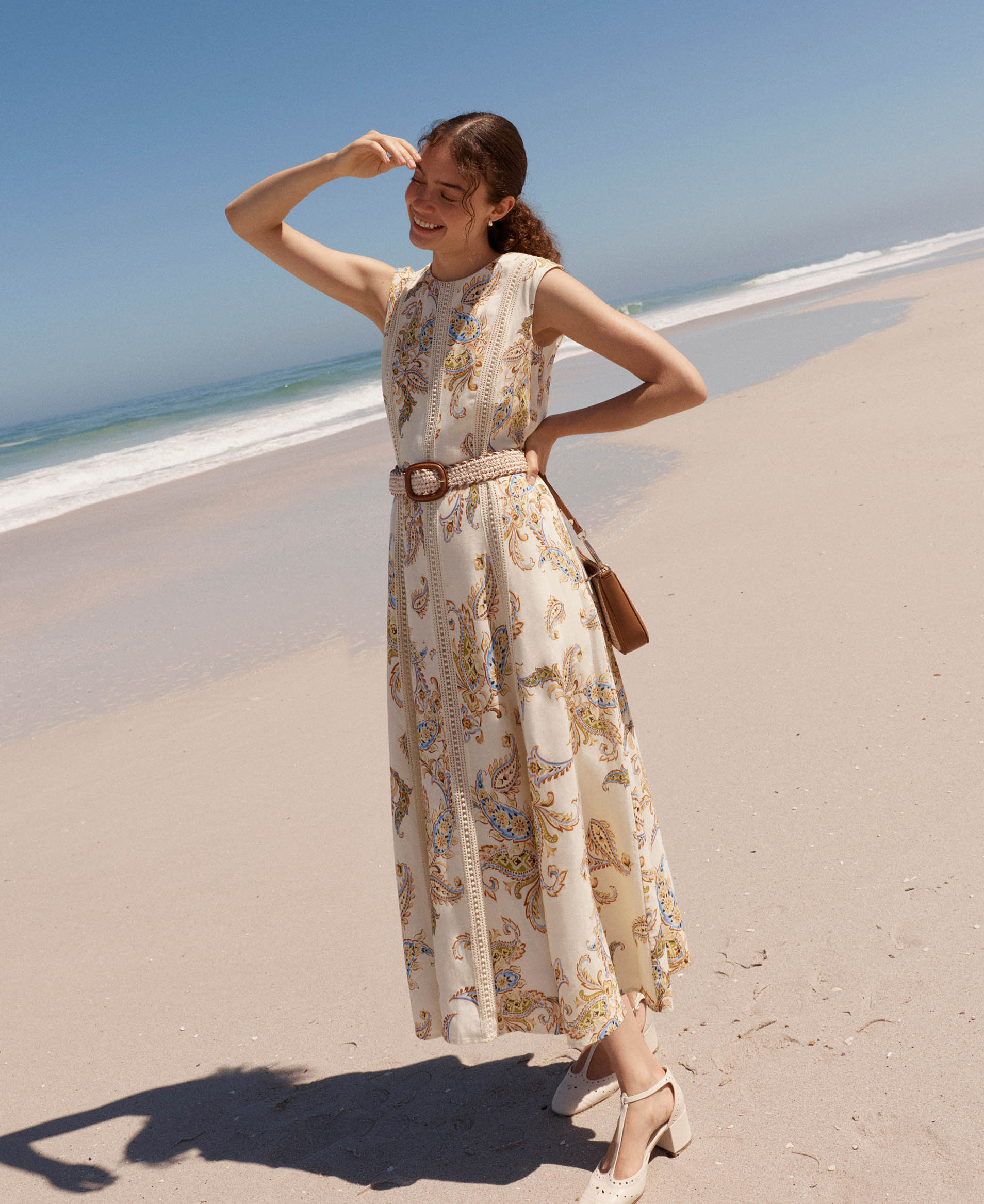A woman wearing a white Hobbs summer dress.