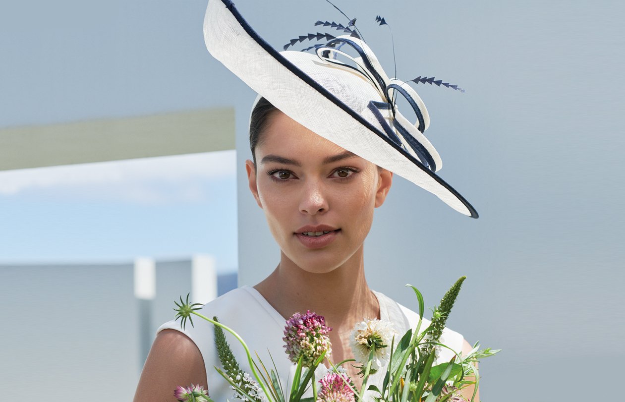 White fascinator with navy blue details, worn with a white dress by Hobbs.