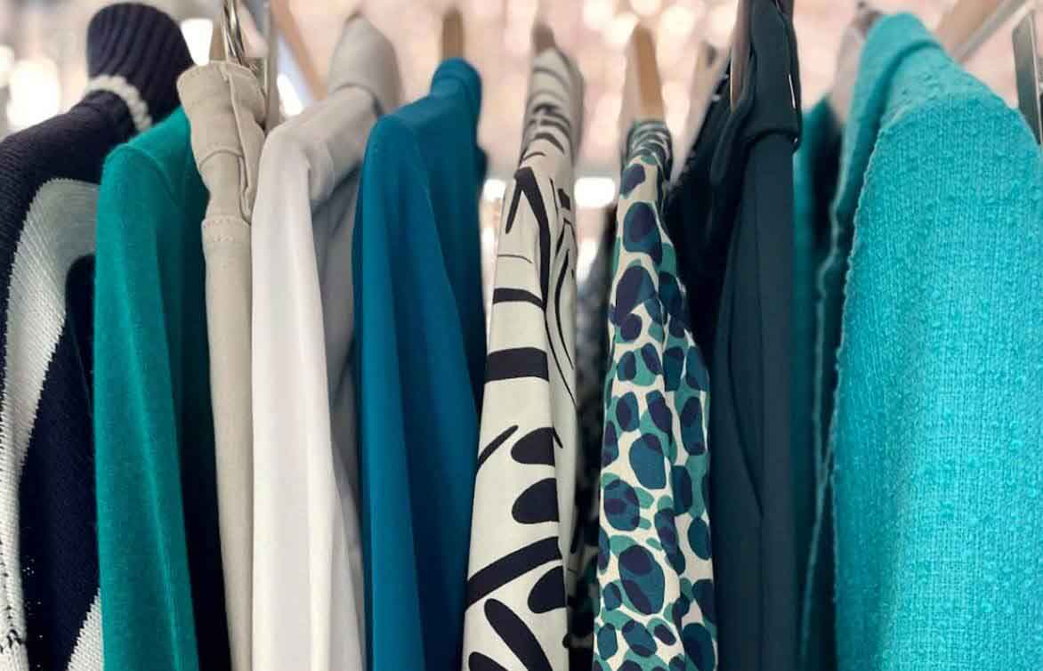 Rail of women's clothing in a palette of blues and greens.