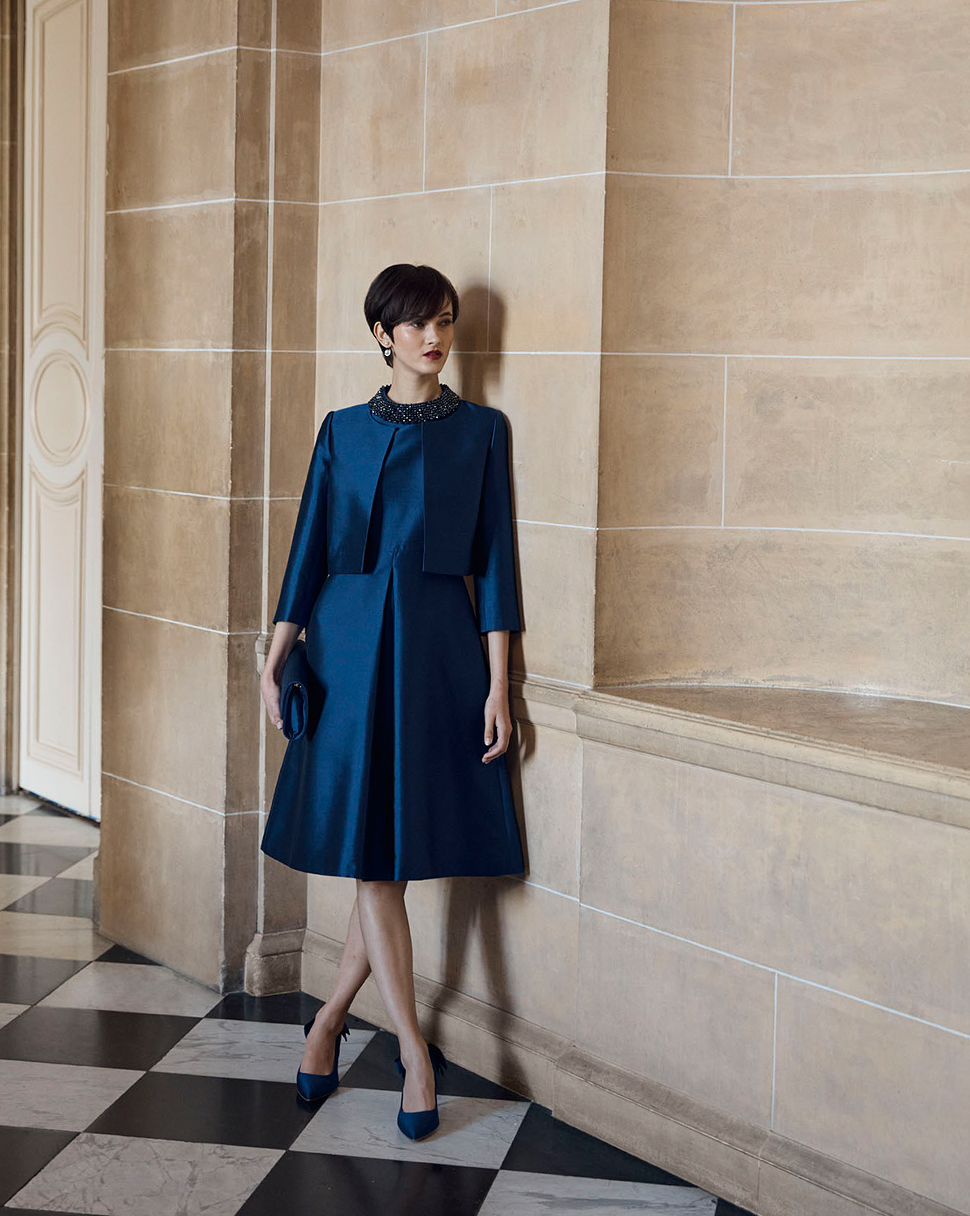 Hobbs model wears a navy silk dress and matching jacket.