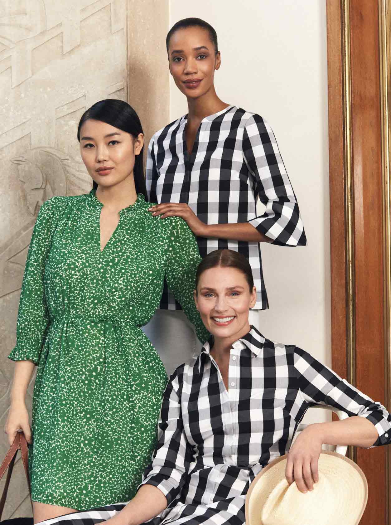 A group of Hobbs models pose wearing a gingham dress, green dress and gingham top.
