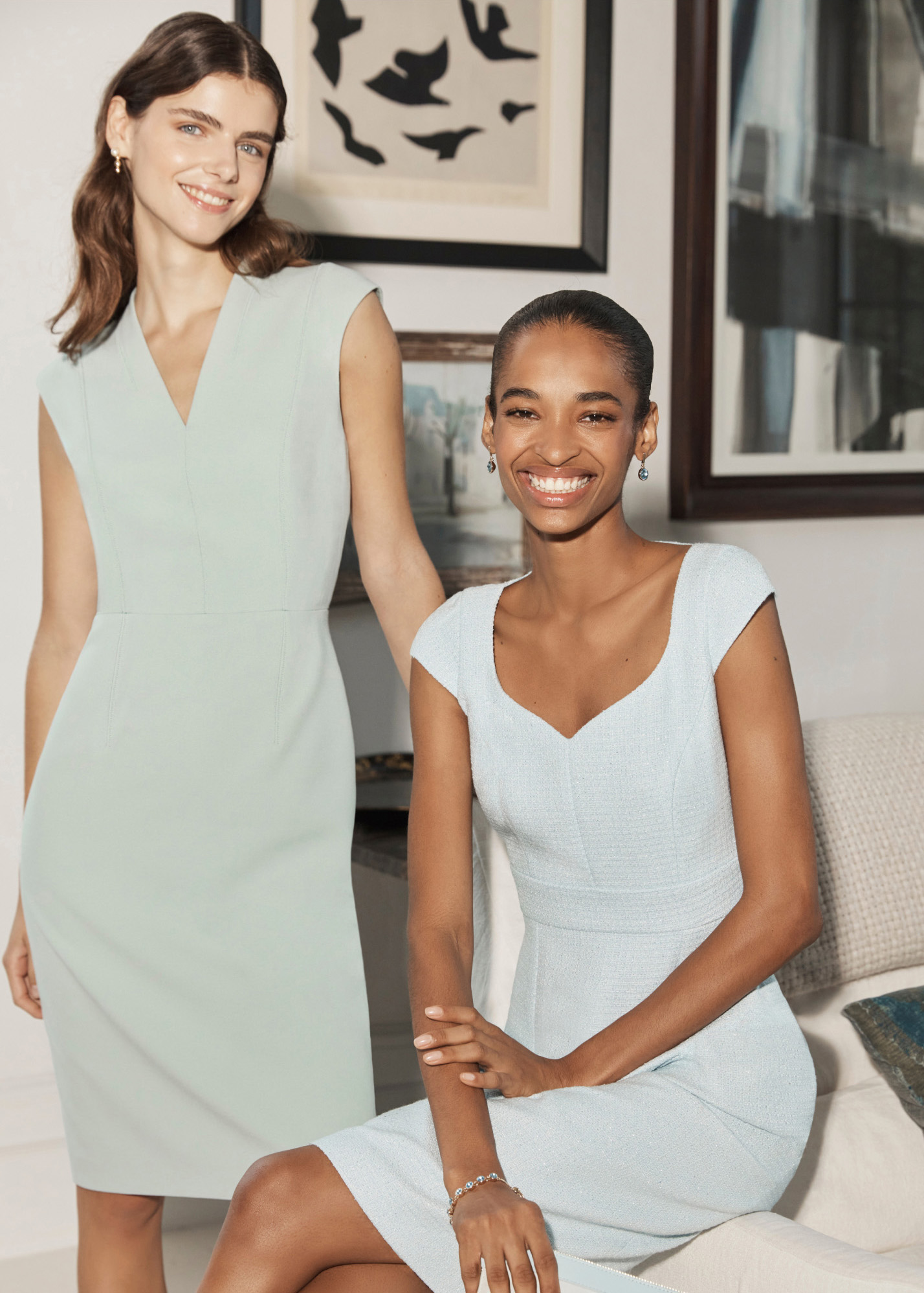 Image of two models at a wedding reception wearing occasion jackets and dresses.