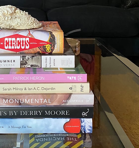 A pile of books on Jason's coffee table