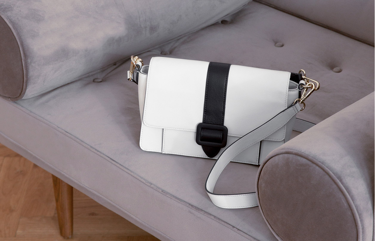 Hobbs satchel bag displayed on a grey sofa. 