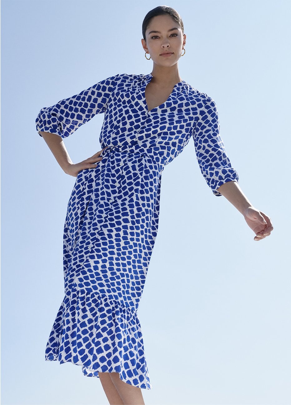 Fit and flare dress with a spot pattern in blue and white featuring a frill hem and a tie waist paired with black espadrille wedge sandals by Hobbs.