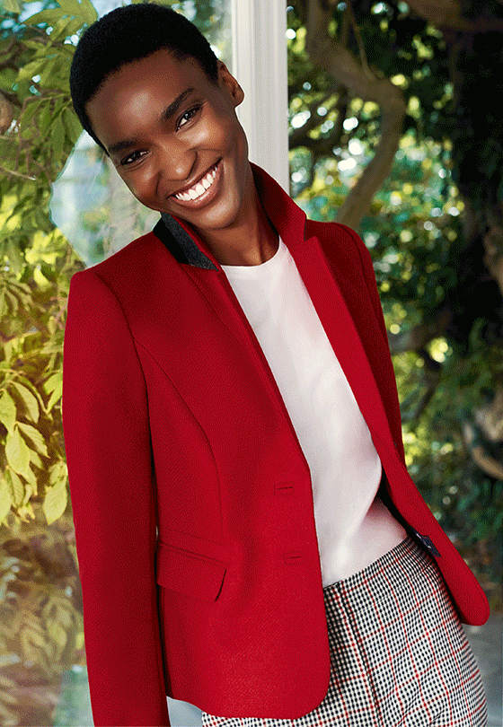 Close-up image of model wearing a Hobbs red jacket over a white t-shirt.