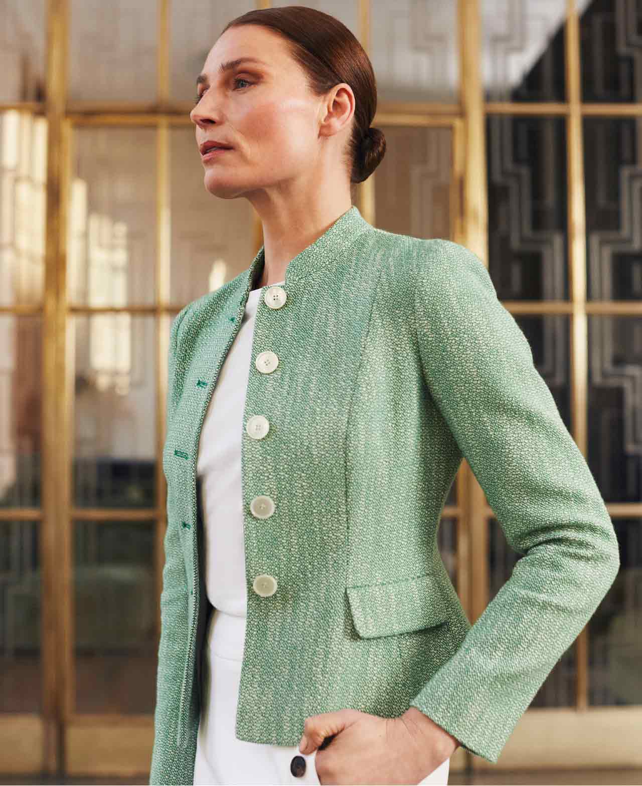 Hobbs wears a green tailored tweed jacket and white trousers.