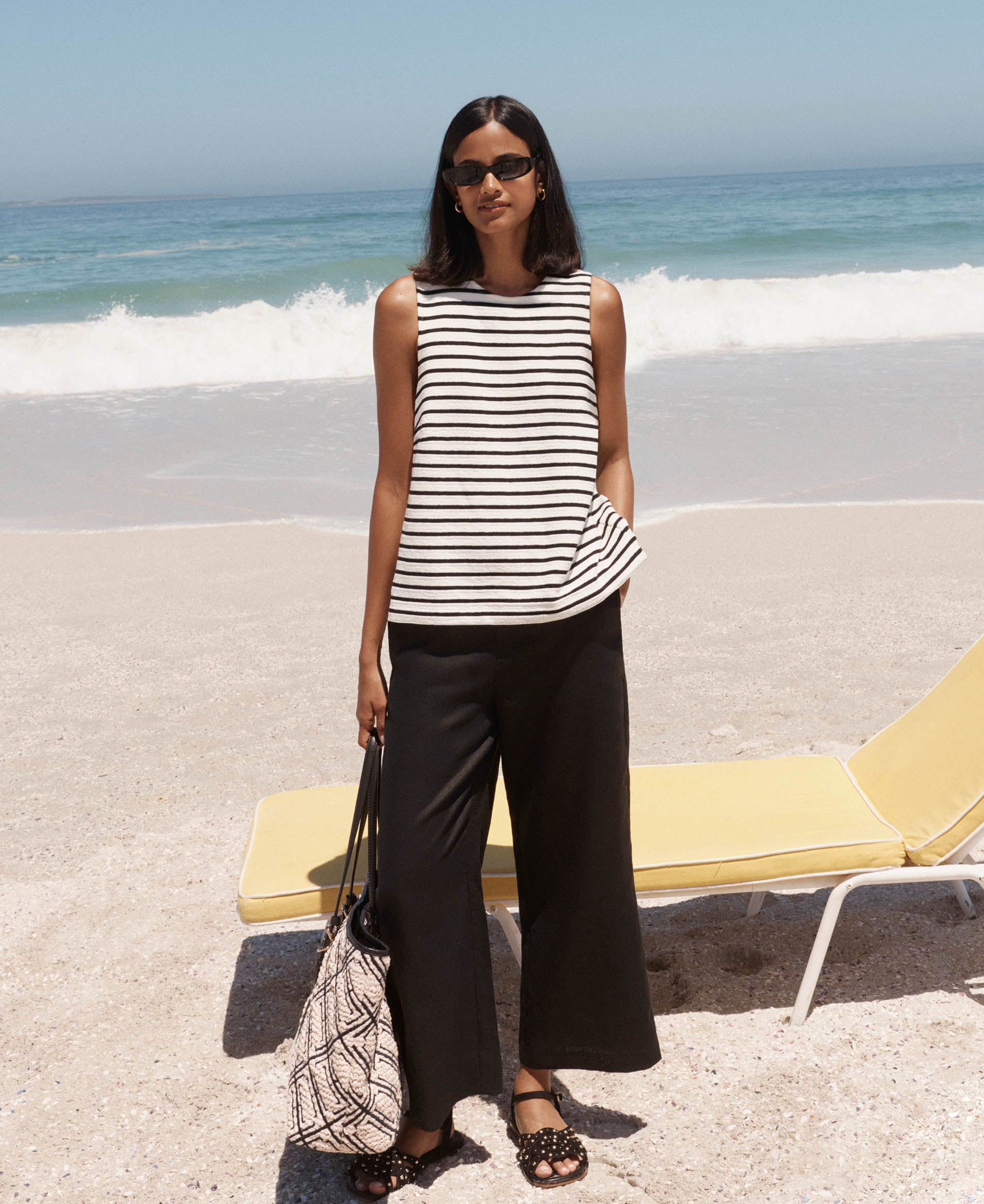 A woman wearing a Hobbs striped top and linen trousers.
