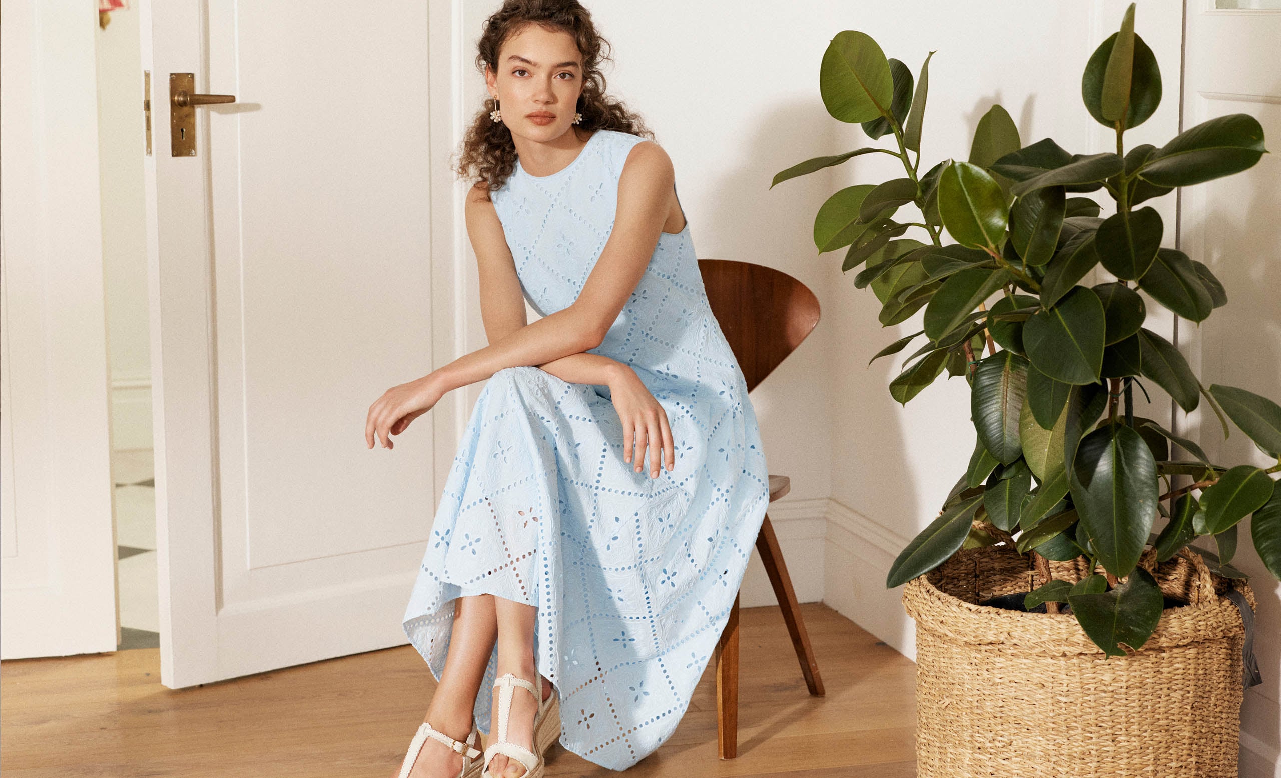 A woman wearing a broderie, petite occasion dress.