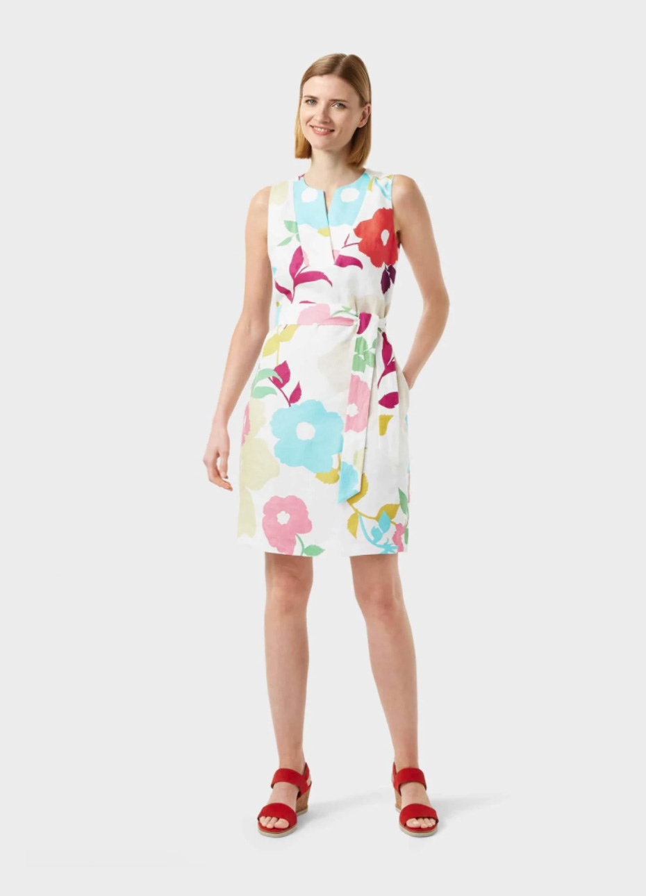 White shift dress with a multi-coloured floral pattern with a waist-tie paired with red block heel sandals by Hobbs.