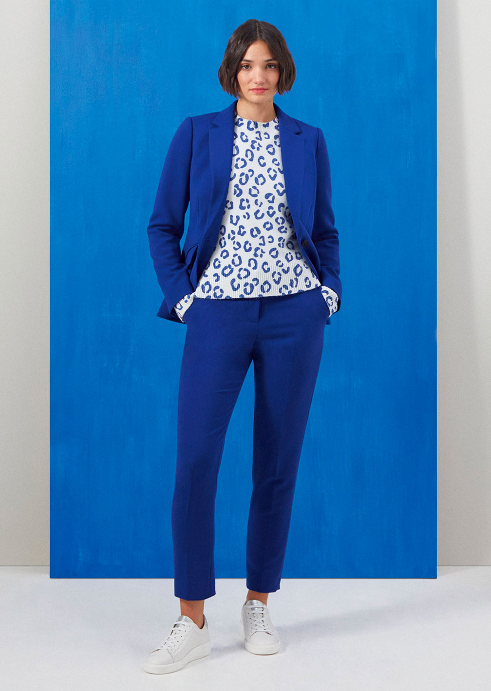 Model wears Hobbs Suki tailored blue jacket with matching Suki slim leg trousers.