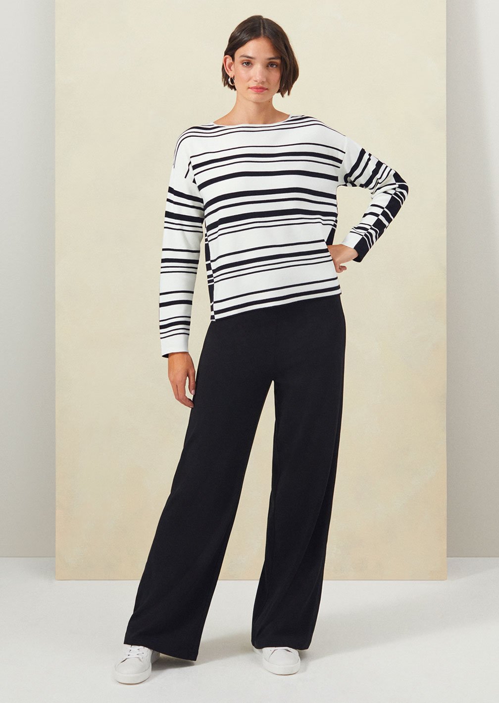 Model wears Hobbs Brigitte striped jumper with Dani black wide leg trousers.