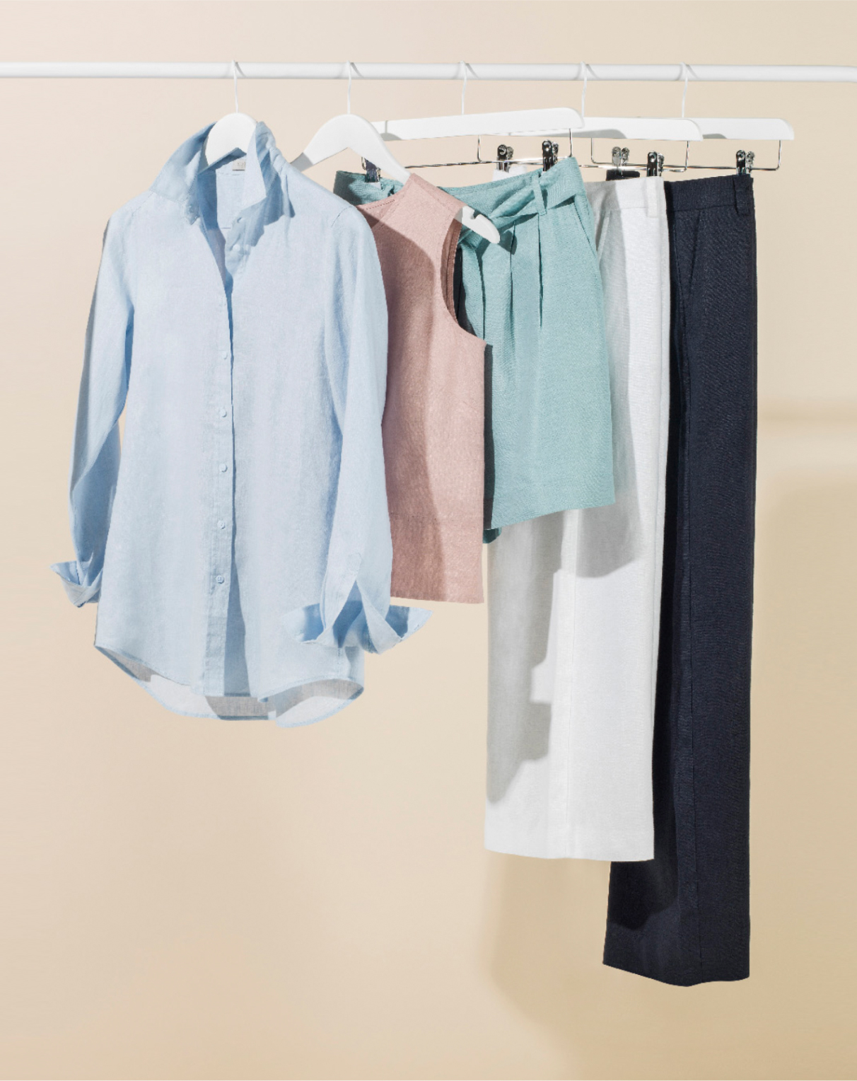 A rail of linen clothes including a shirt, shell tops, shorts and trousers.