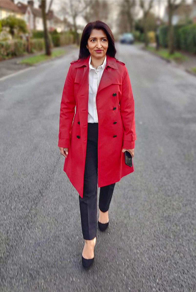 Photographed walking along her street, fashion blogger Monika Mandal wears Hobbs petite red Saskia trench.