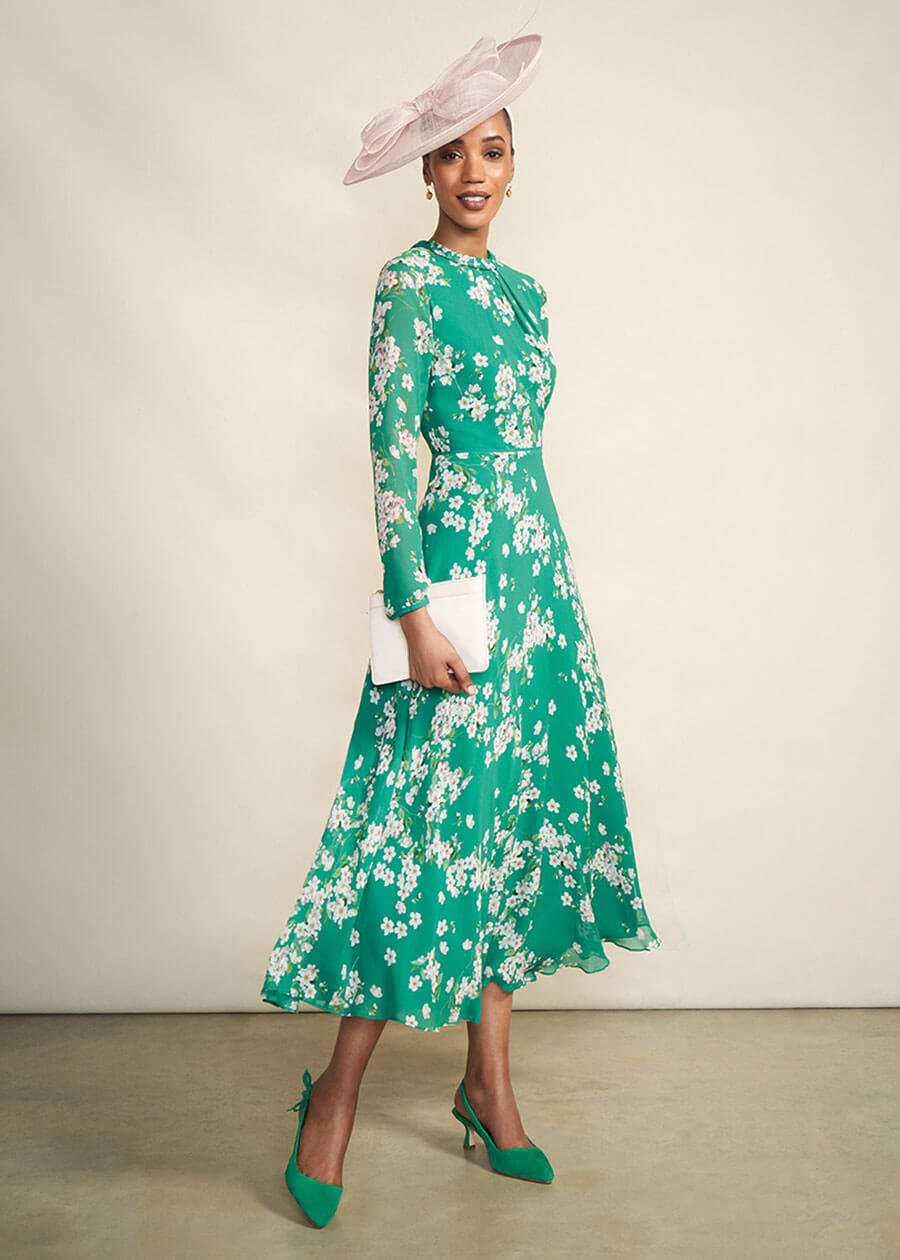 Model photographed against a canvas background wearing a Hobbs floral dress.