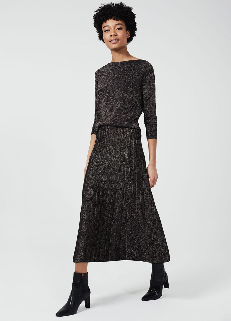 Hobbs model wearing a long sleeve sparkly knitted dress with black pointed leather ankle boots for women.
