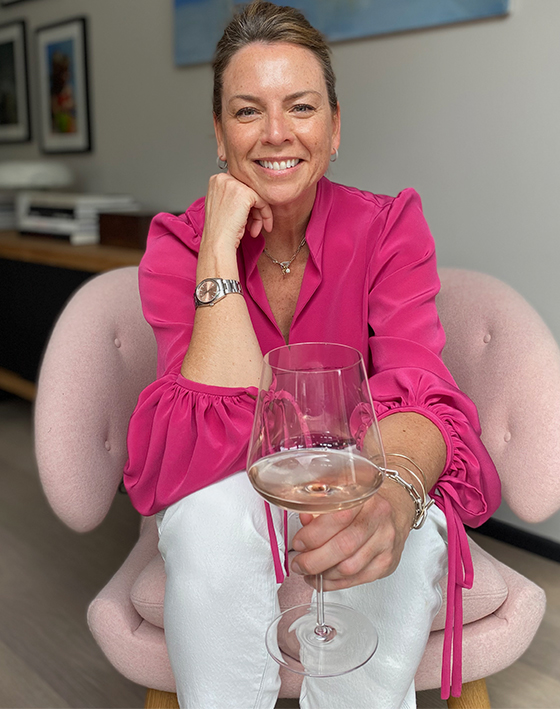 Sally Ambrose, Hobbs Product Director pictured at home in a pink blouse and white jeans 