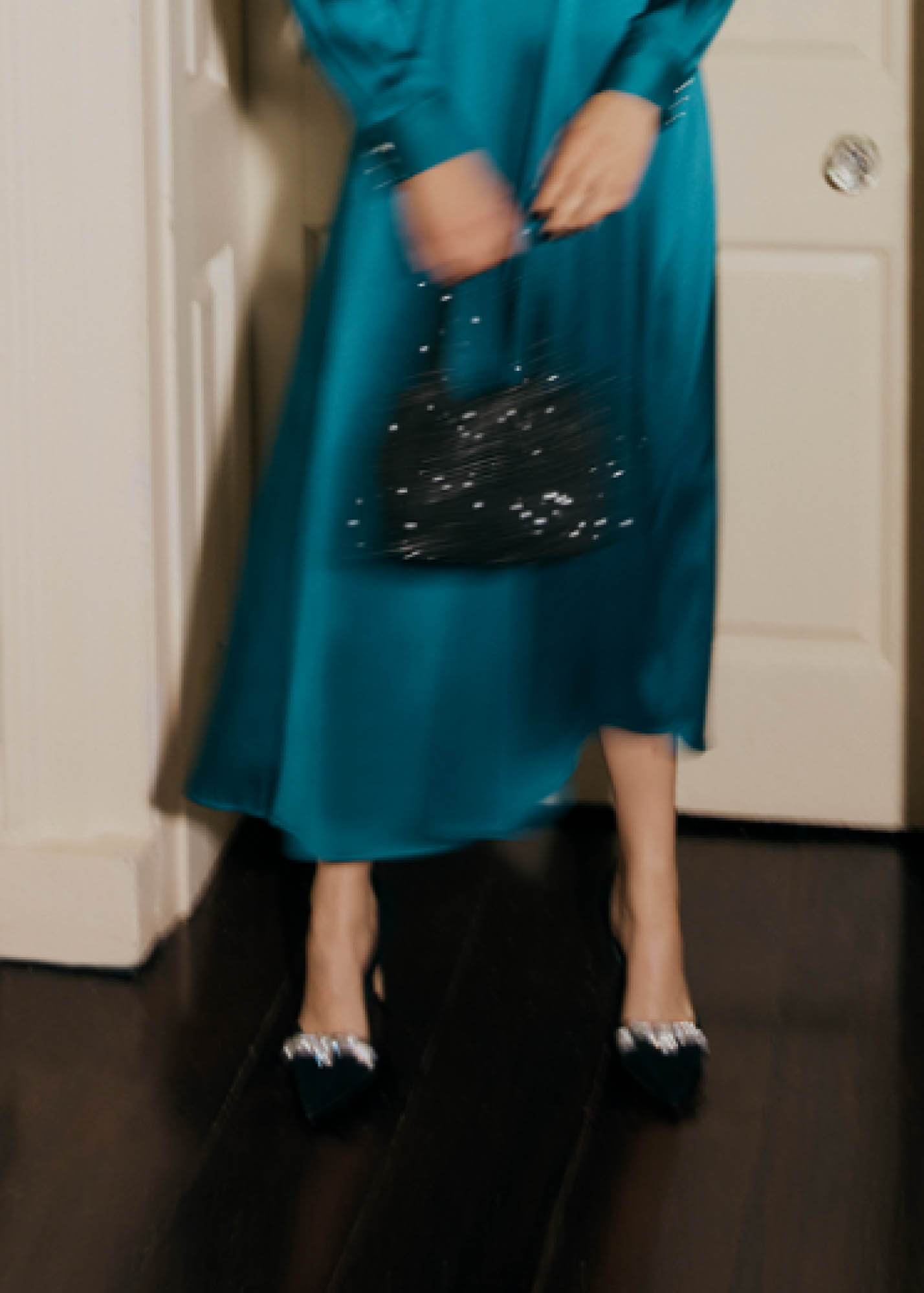 A close-up image of a model holding a jewelled bag