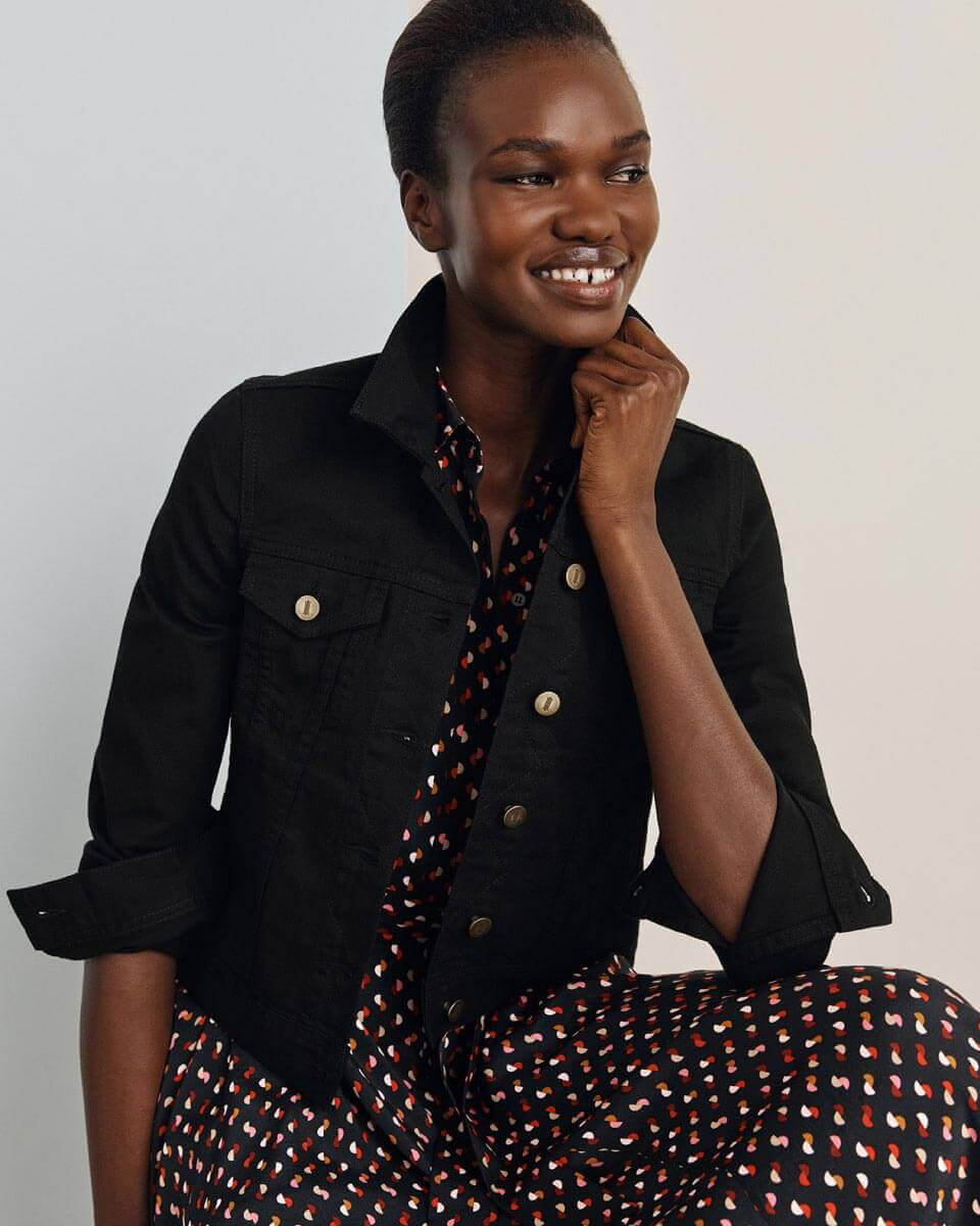 Hobbs model photographed wearing an abstract print shirt dress and black denim jacket.