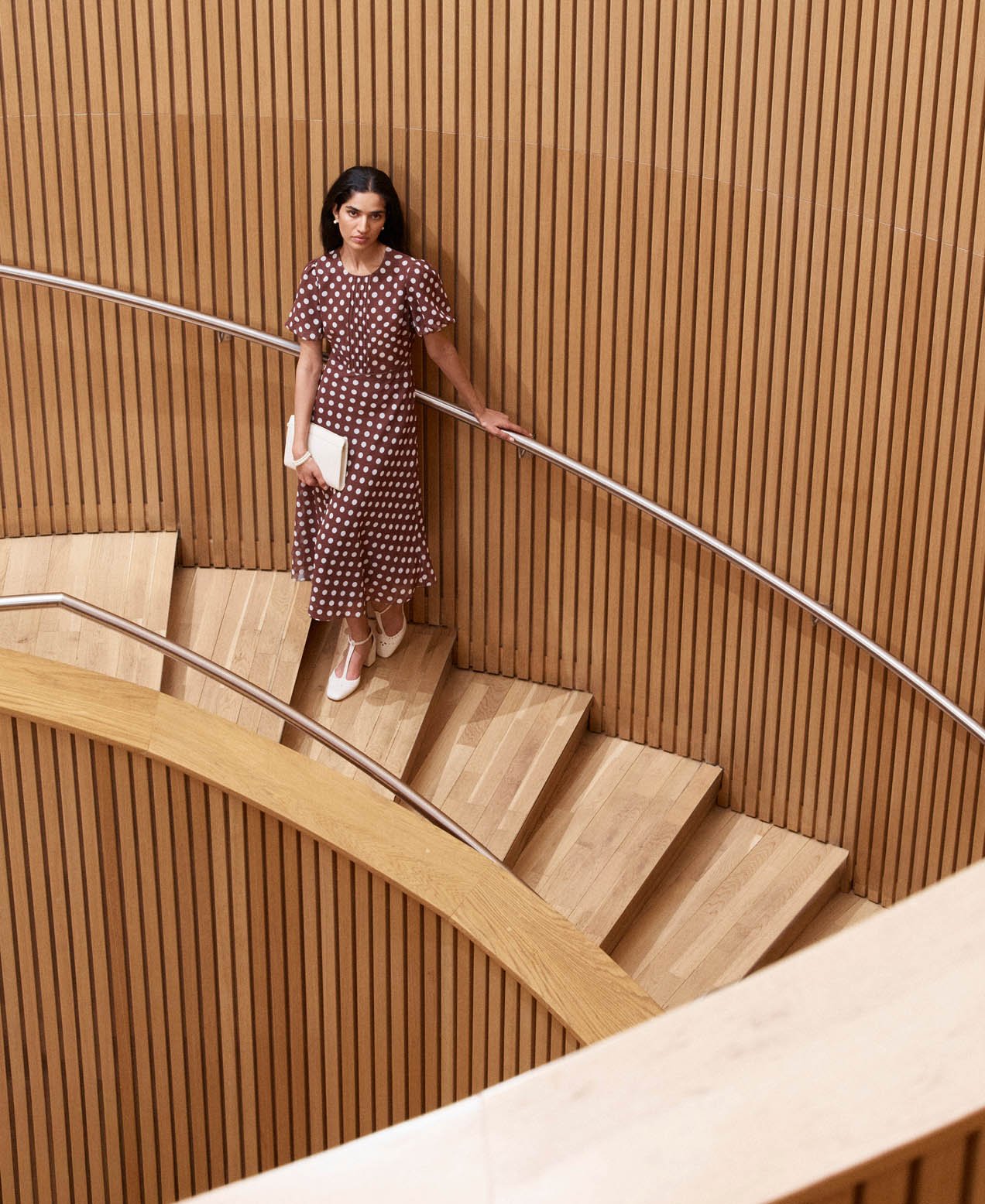 A woman wearing a brown polka dot dress.