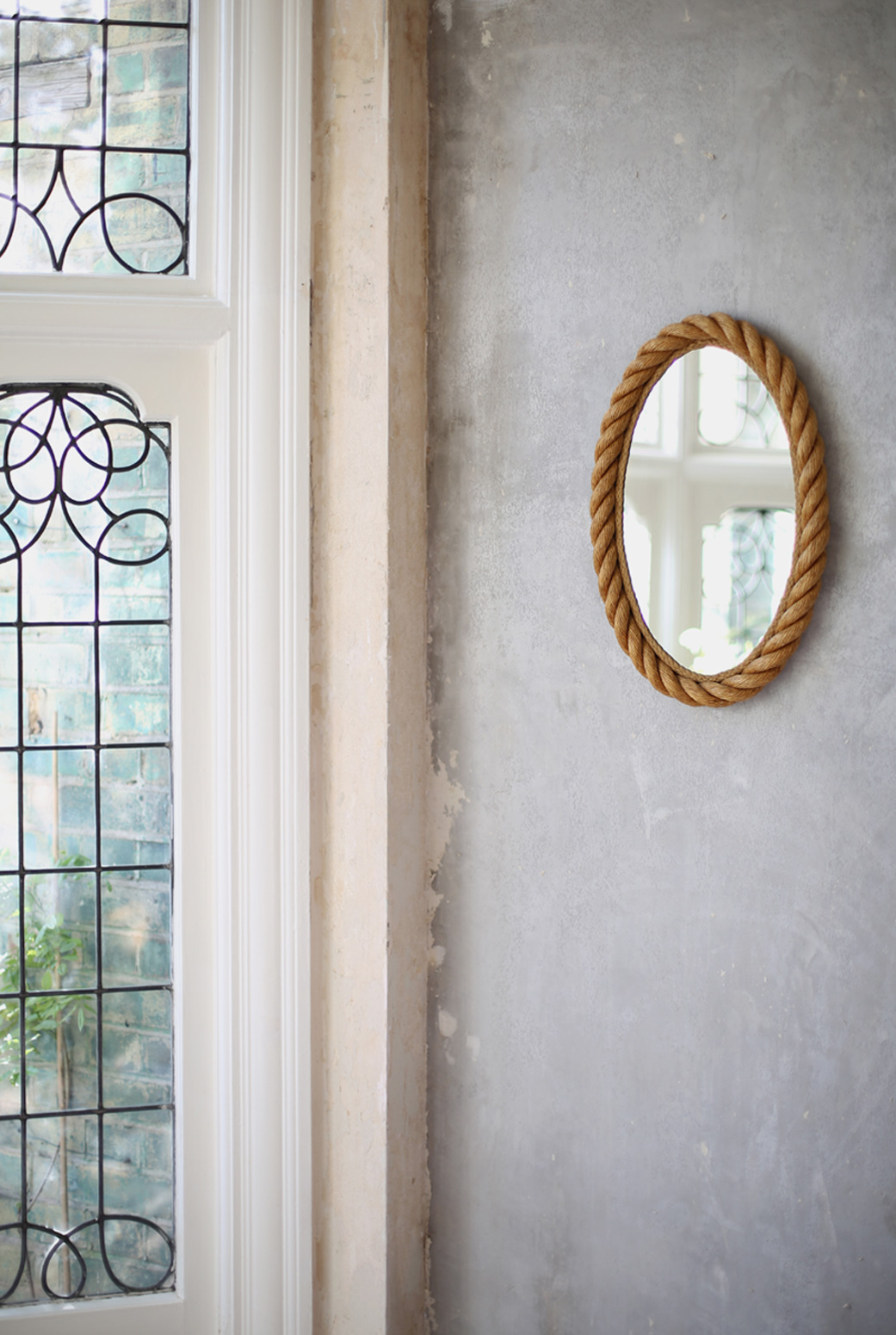 A mid century rope mirror reflects the light in Hannah's home. 