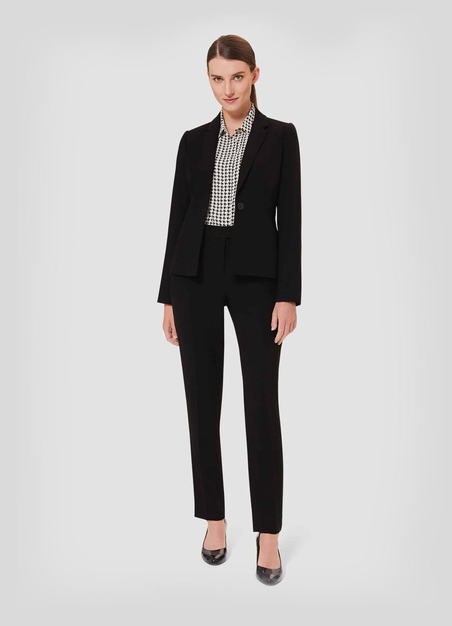 Women’s trouser suit for work worn with a dogtooth patterned shirt and black court shoes by Hobbs.