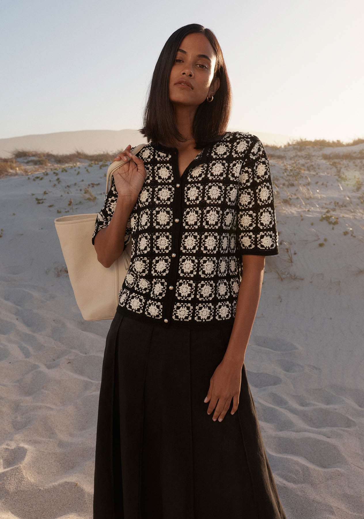A woman wearing a Hobbs crochet monochrome top.