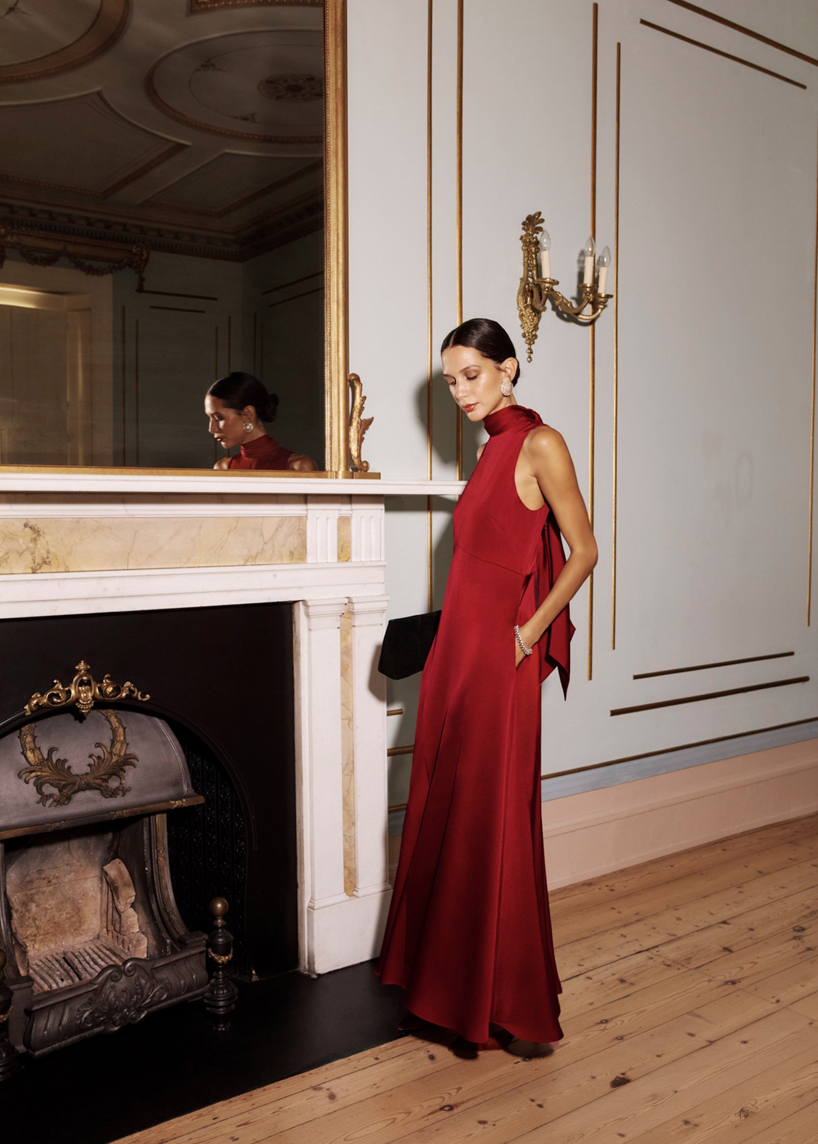 A woman wearing a red  maxi dress with a tie neck detail.