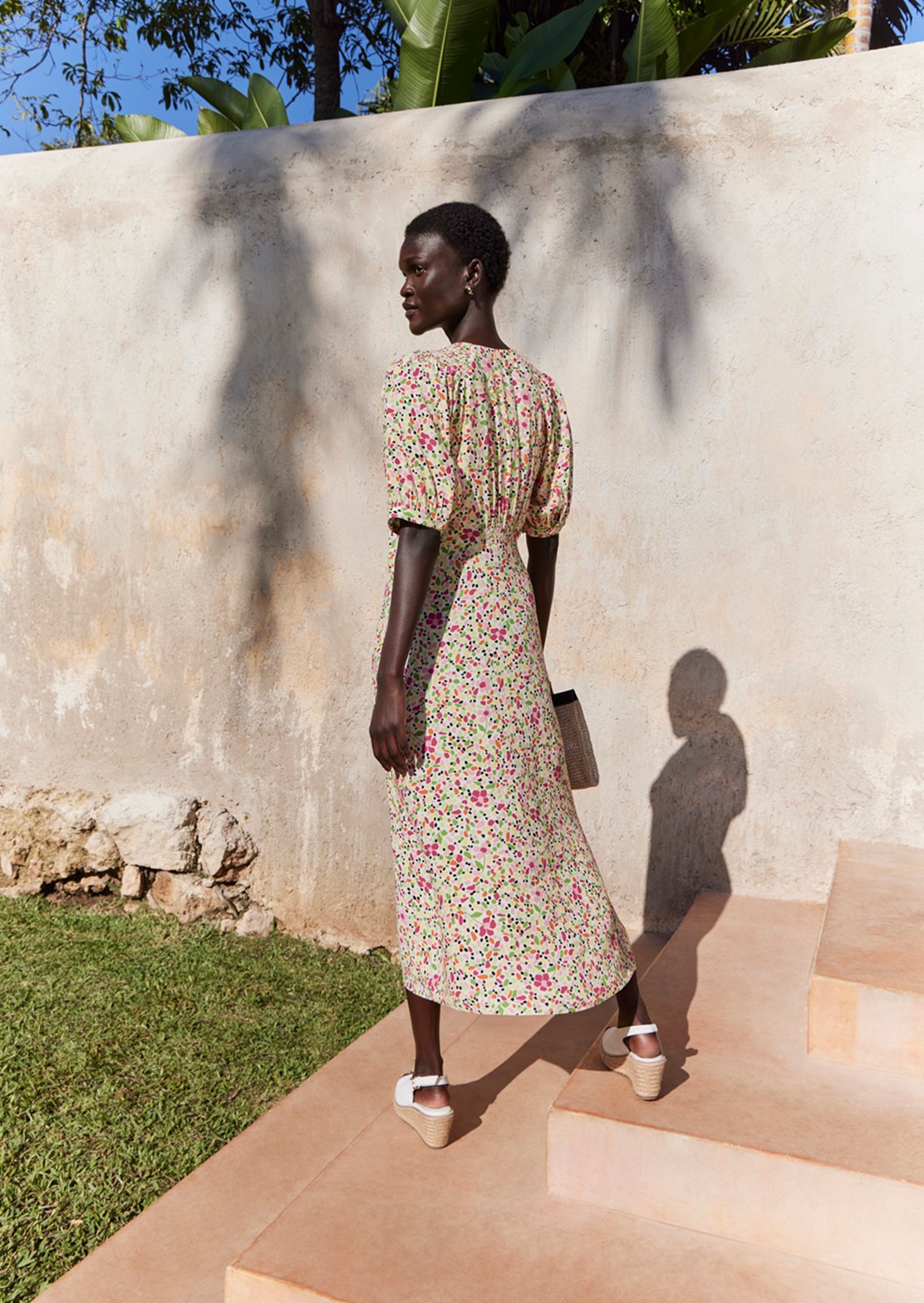 A collage of two images showcasing a model wearing a Hobbs’ ditsy print floral dress.