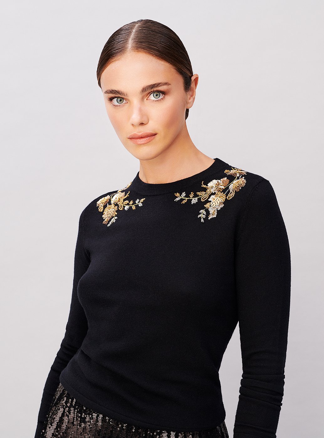 A bead embellished jumper worn with a sequin midi skirt from Hobbs.