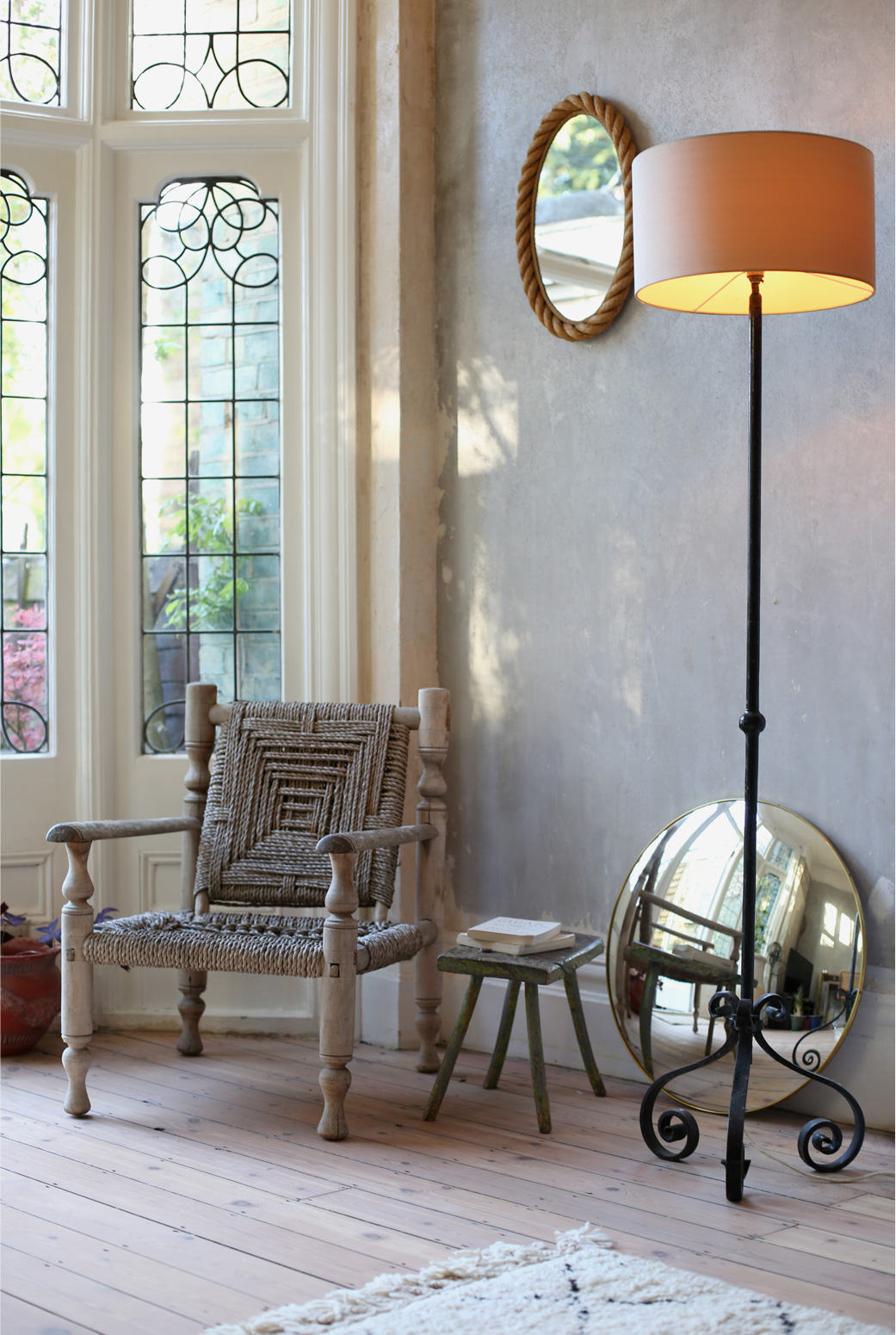 Bring the outside in, beautiful leaded windows in Hannah's flat featuring a mid-cenury rope chair and a wrought iron table lamp.