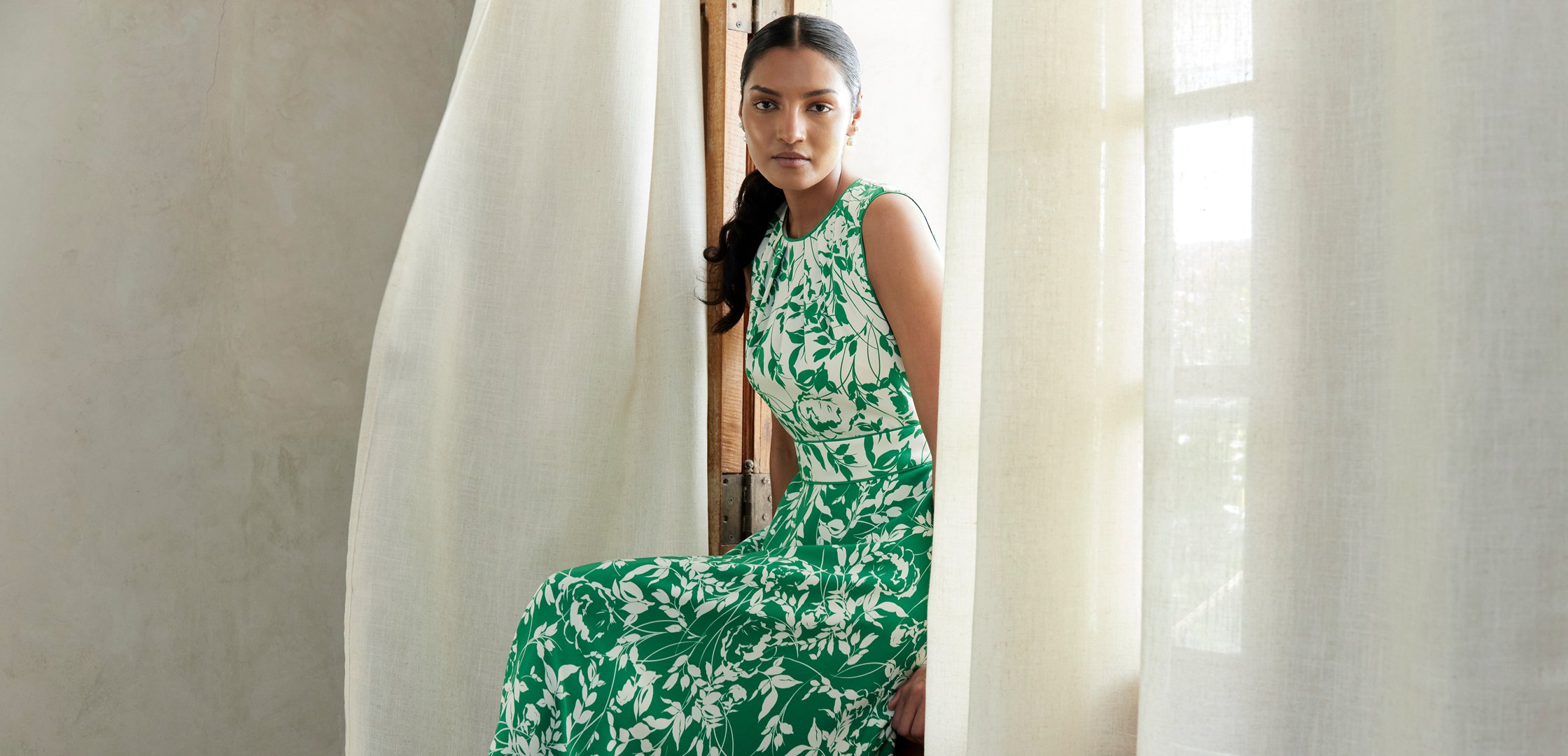 An image of two models wearing Hobbs floral occasion dresses.