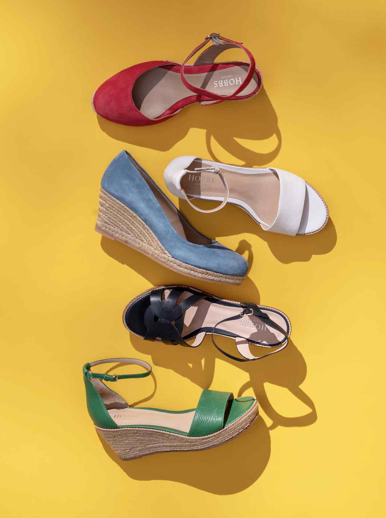 A collection of colourful Hobbs espadrilles on a yellow background.