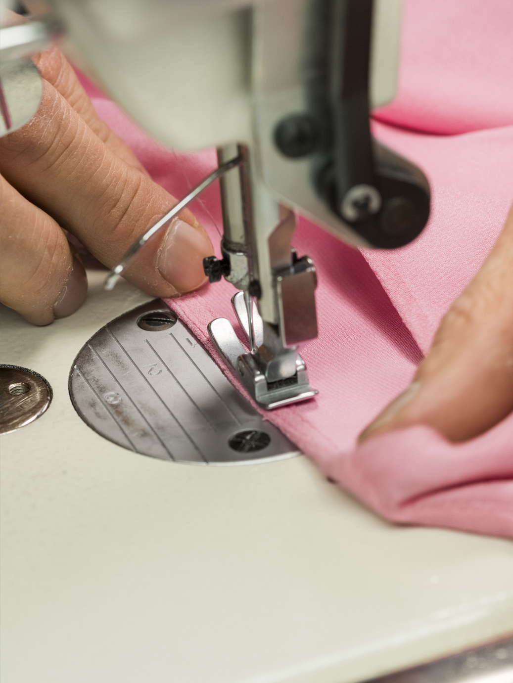 Sewing machine stitching pink fabric 