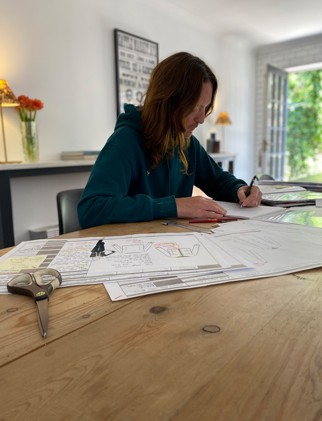 Jason works on the upcoming spring summer 2021 collection on the dining table at home