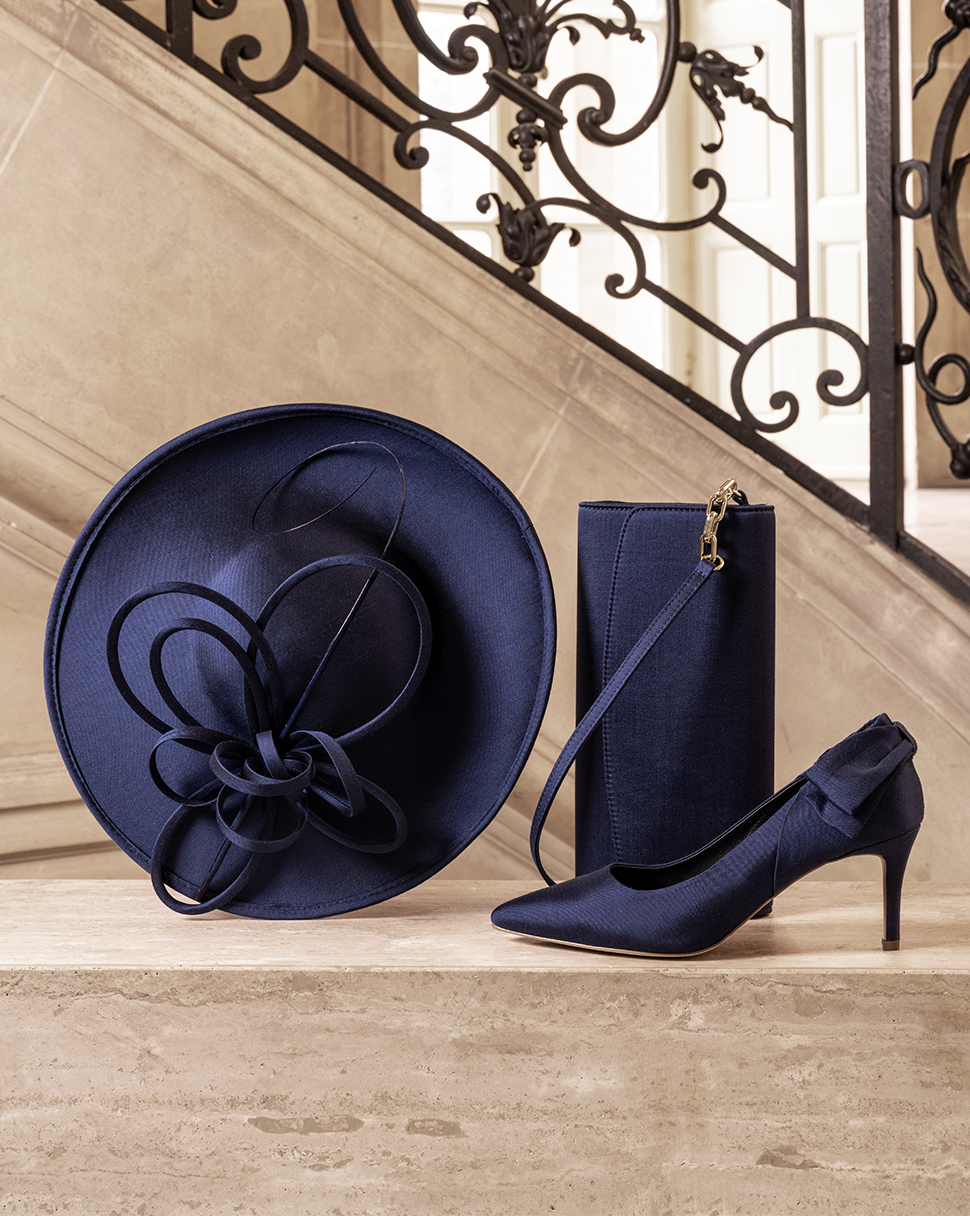 An arrangement of navy fascinator, bag and shoes together.