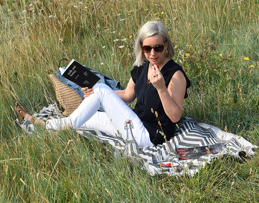 Jen Wilkins, Creative Copy & Editorial Manager at Hobbs enjoys a picnic with some strawberries in a secluded spot by the coast while reading a book.