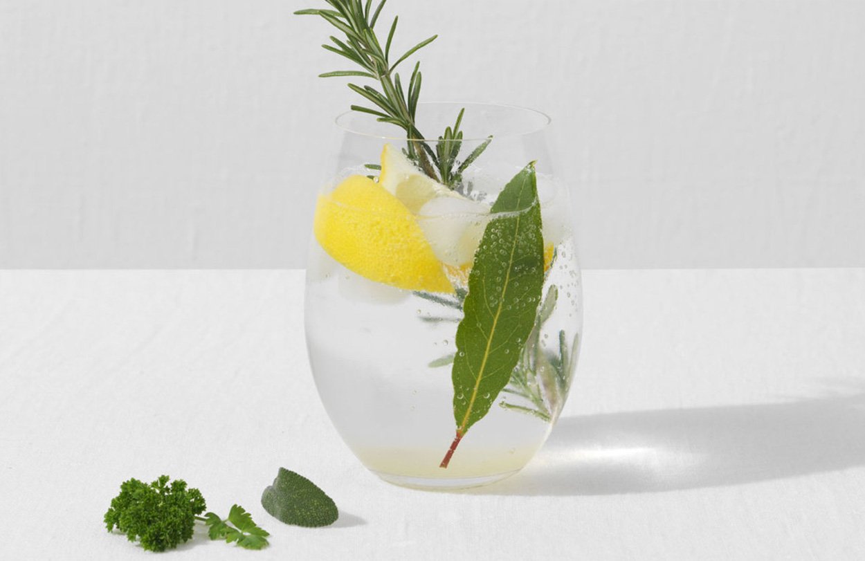 Glass containing refreshing Gin Fizz Cocktail with Lemon and Rosemary