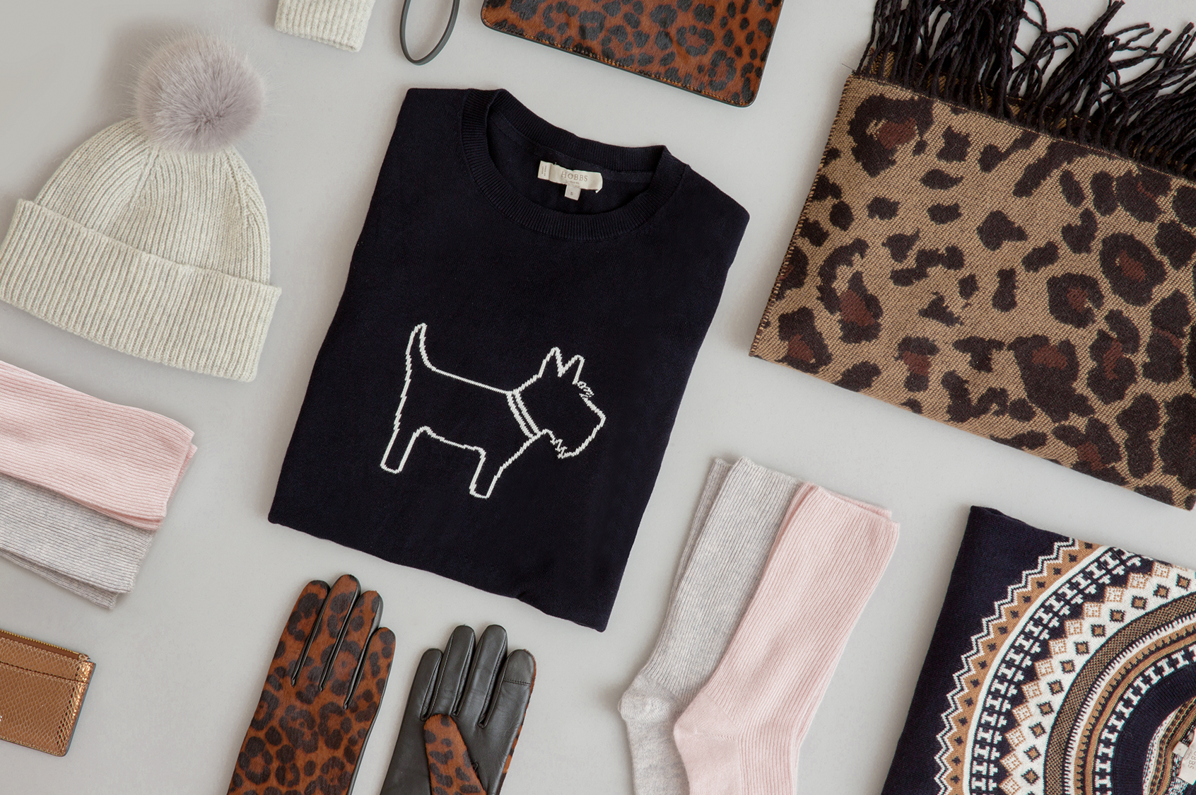 A selection of Christmas gifts including a novelty knit, leopard print scarf and gloves.