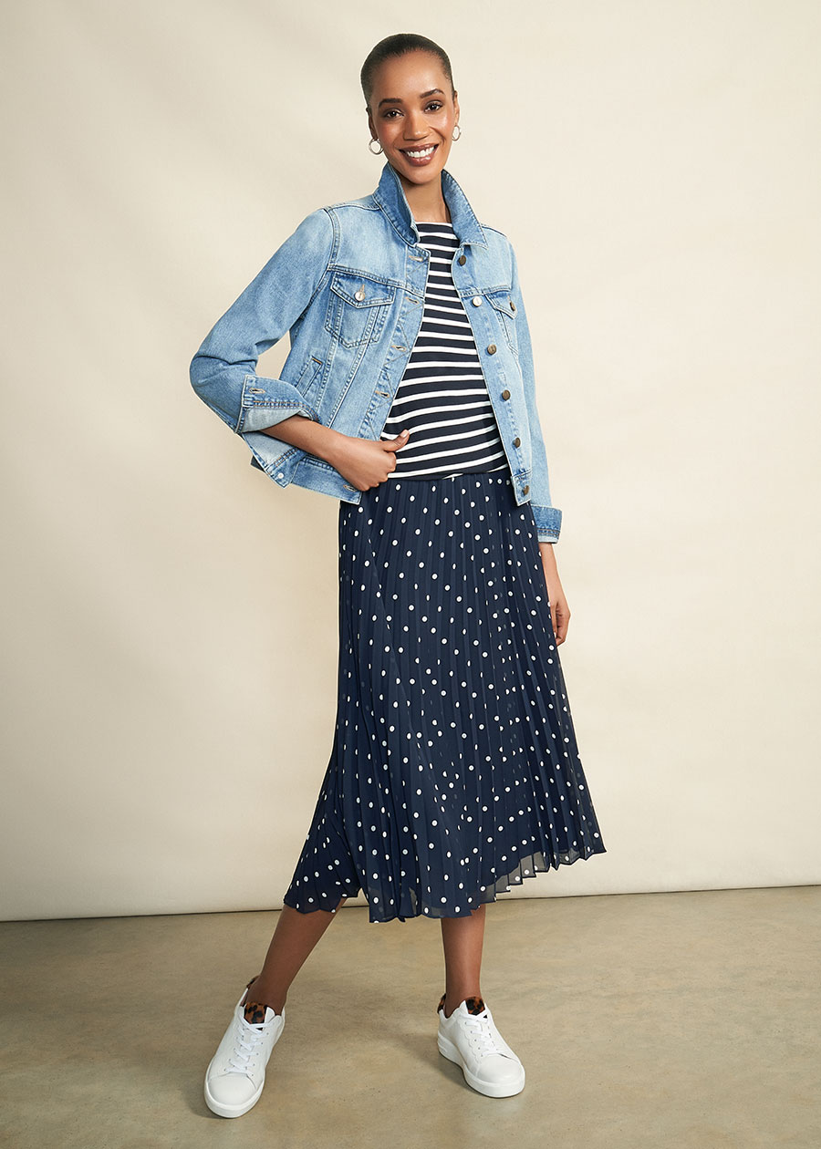 Model photographed against a canvas background wearing Hobbs Mariam denim jacket, striped top, polka dot skirt and trainers.