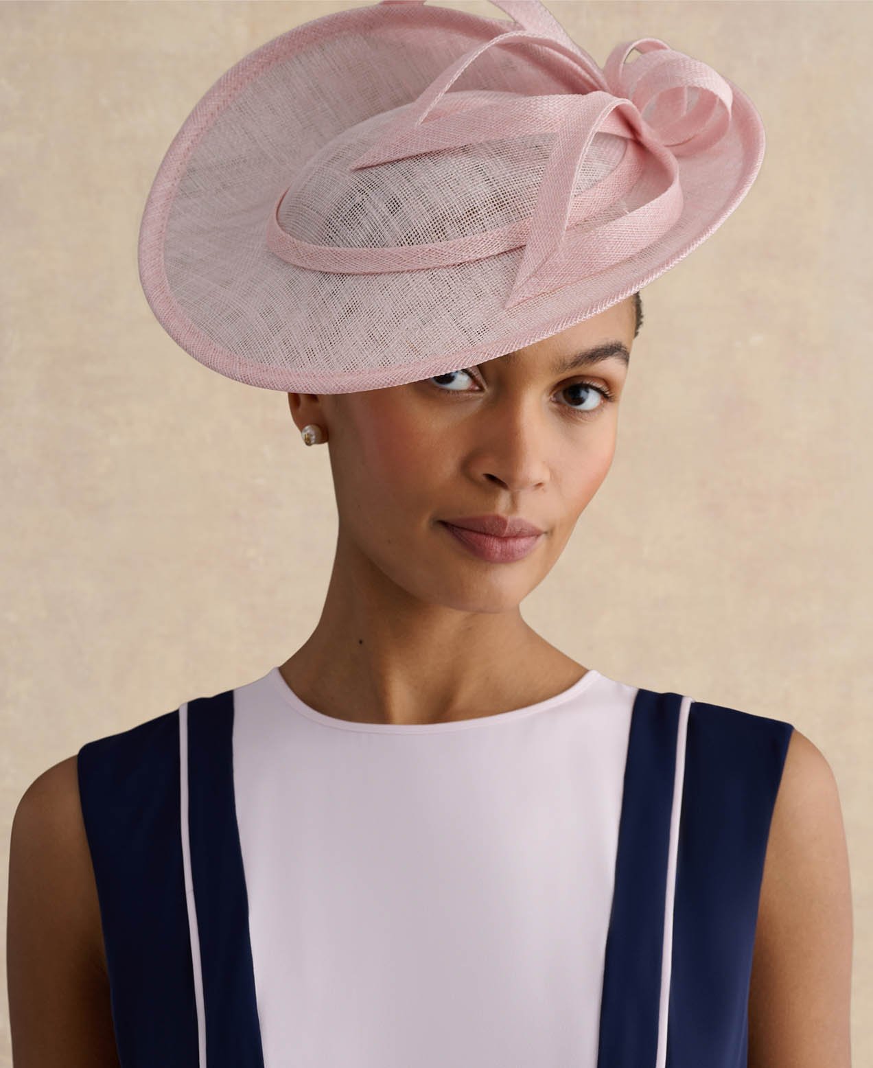 A woman wearing a pale pink fascinator.