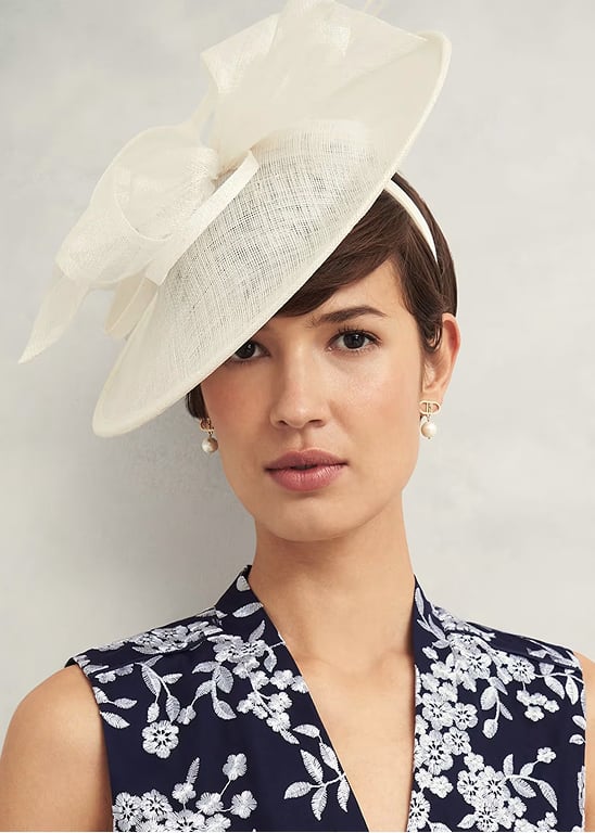 A gallery of four images of models wearing Hobbs fascinators.