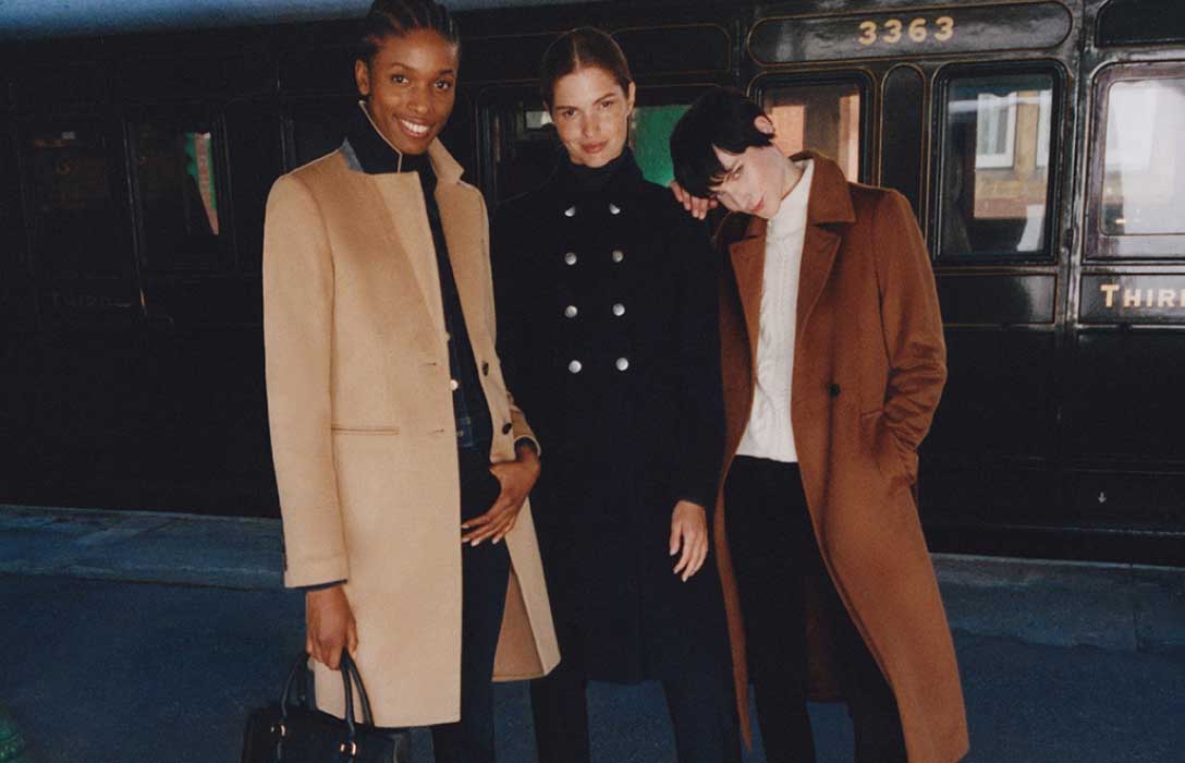 Three models photographed on a station platform wearing Hobbs wool coats.