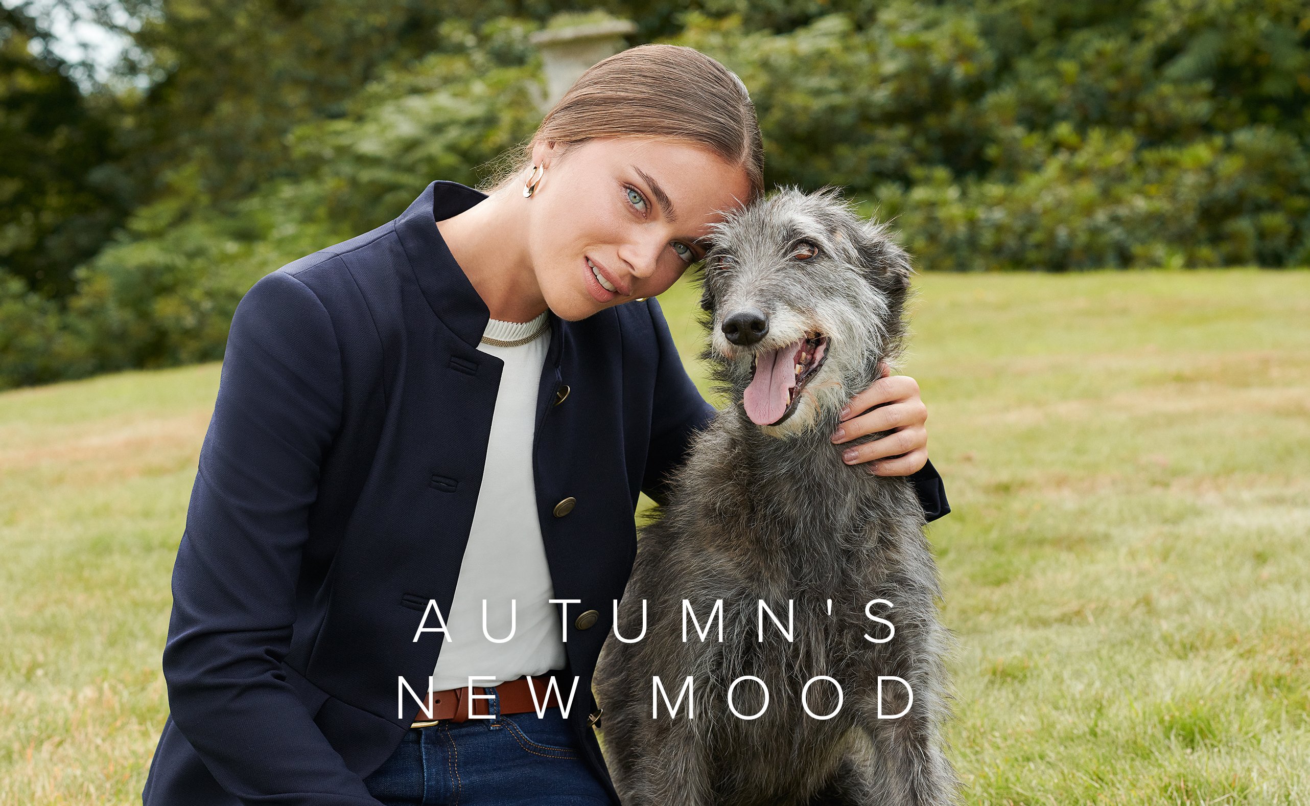 Model poses in a blue blazer next to a dog