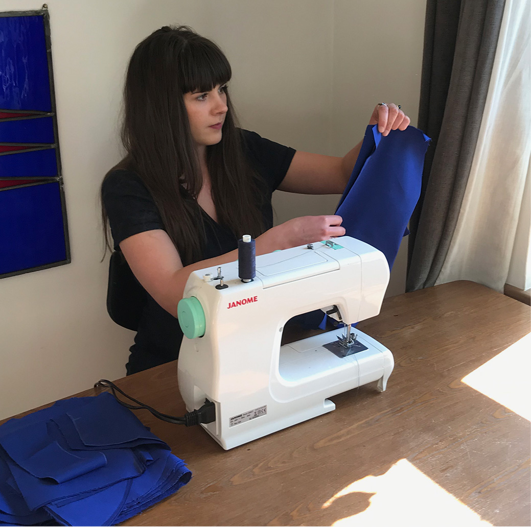 Laura at home sewing scrubs for charitable organisation scrub hub 