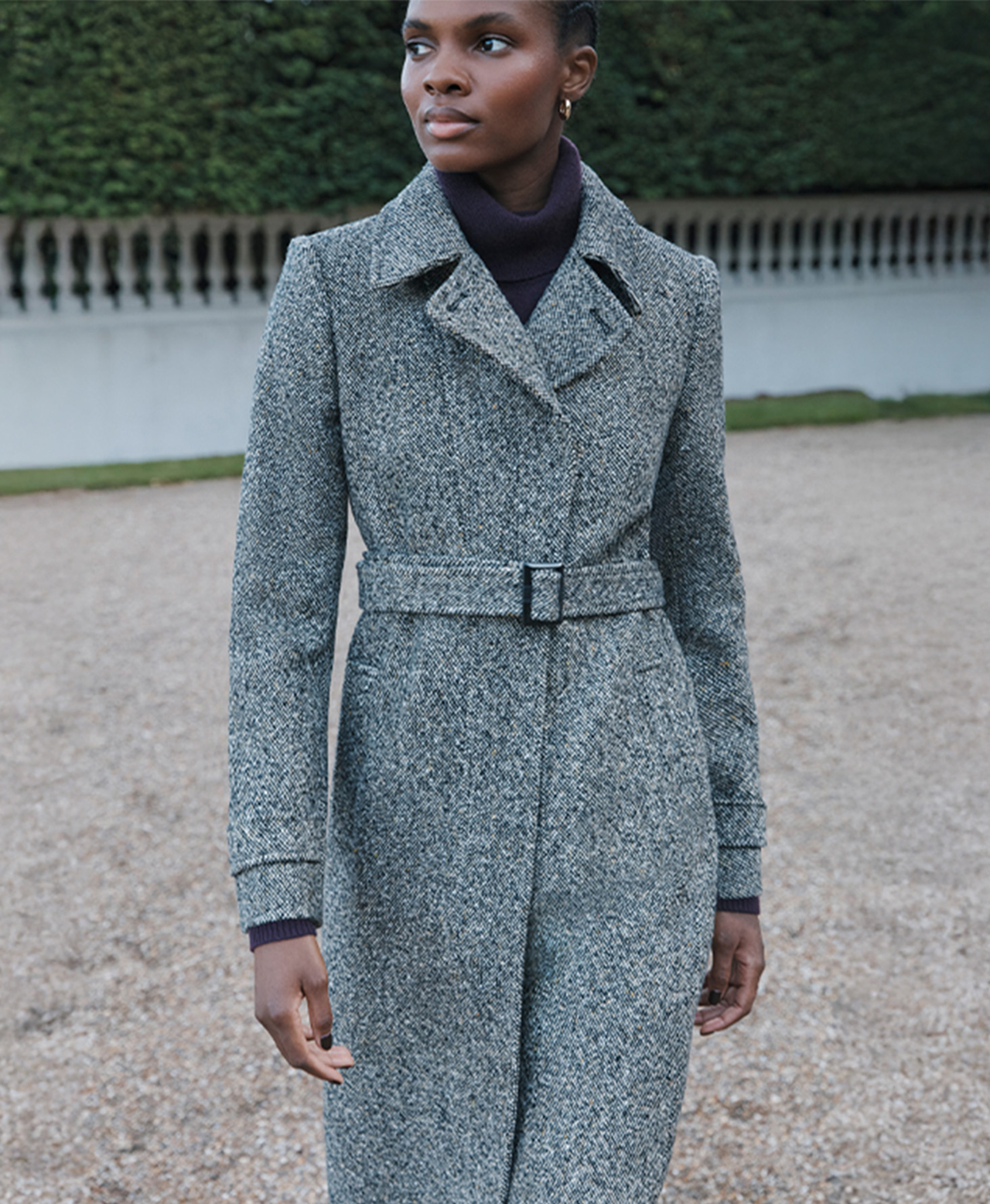 A woman wearing a salt-and-pepper weave, wool coat.
