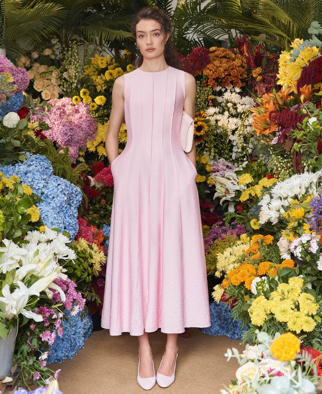 A woman wearing a plain, maxi occasion dress.